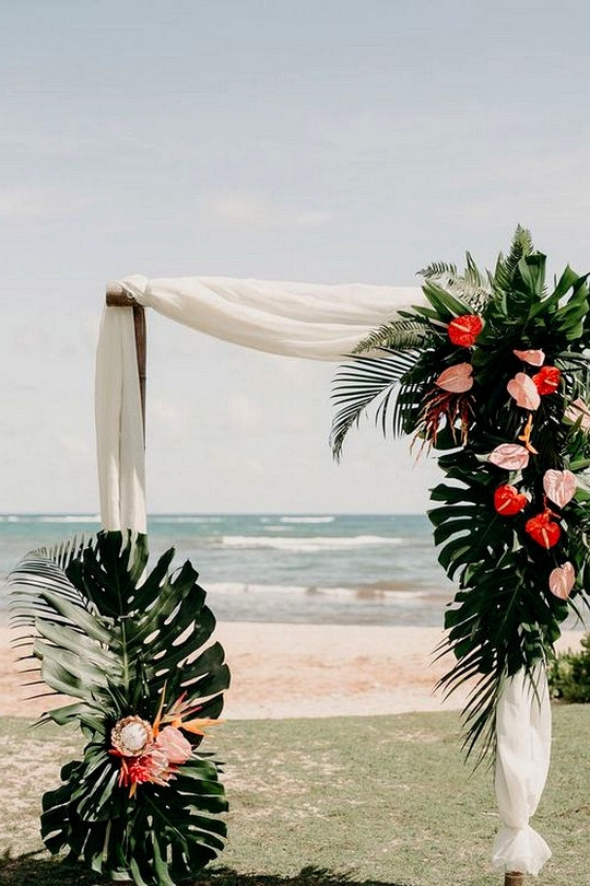 beach tropical wedding arch ideas with lush greenery and pink floral