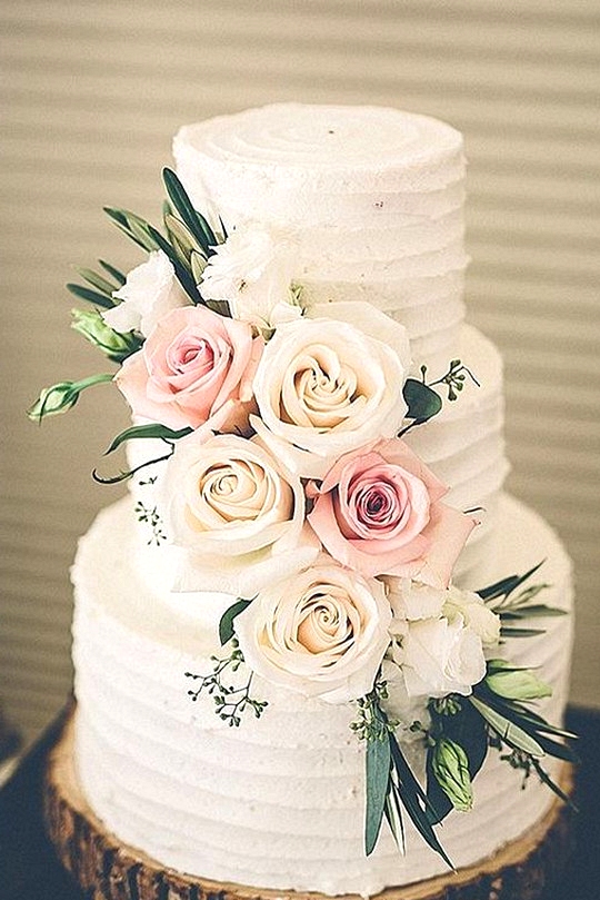 chic floral wedding cake with tree stump stand