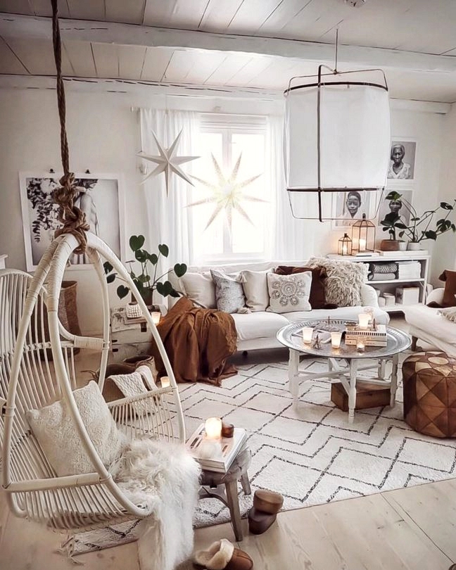 Scandinavian Bohemian white living room with white hanging rattan chair and brown Moroccan Round Leather Pouf